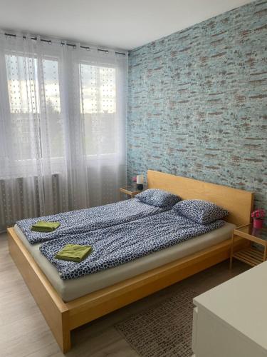 格德勒Dózsa Apartman的一间卧室设有一张床和砖墙