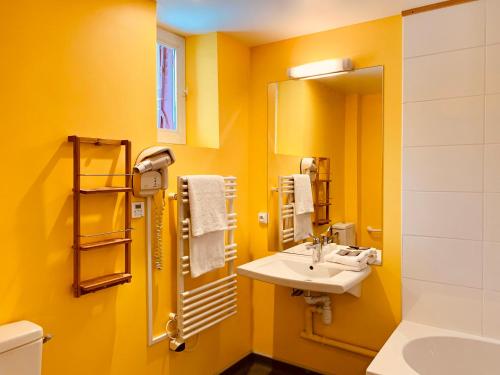 贝斯和圣阿纳斯泰斯勒克罗餐厅酒店的黄色的浴室设有水槽和镜子
