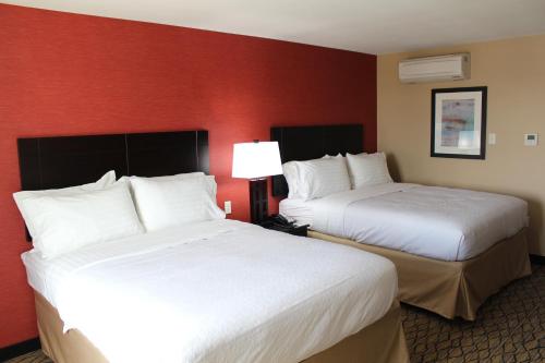 萨利纳萨利纳假日酒店的红色墙壁的酒店客房内的两张床