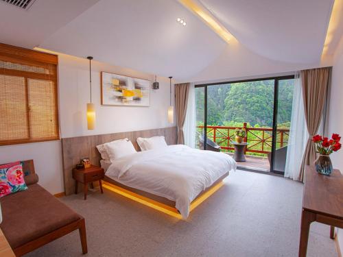 张家界Mount View Cottage的一间带大床的卧室和一个阳台