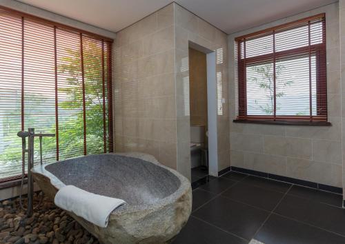 Pu LuongEBINO PULUONG RESORT的带窗户的浴室内的大石头浴缸