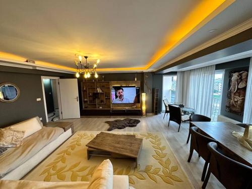 恰纳卡莱Akhome - Luxury dublex apartment的带沙发、桌子和电视的客厅