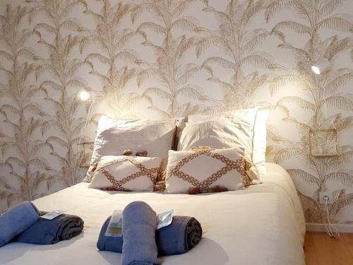 布吕兹Le Coco Playa - Madame Conciergerie的卧室配有白色床和蓝色毛巾