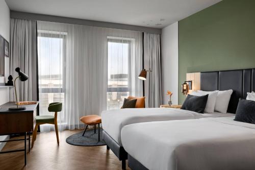 史基浦Renaissance Amsterdam Schiphol Airport Hotel的酒店客房配有两张床和一张书桌