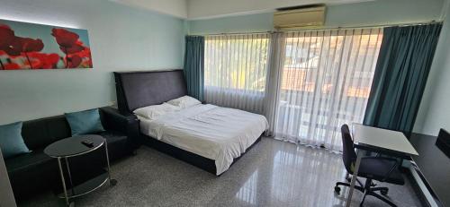 芭堤雅市中心Oasis Rentals, Diana Estate, Pattaya的一间卧室配有一张床、一把椅子和一张书桌