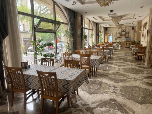 巴库Golden City Hotel Baku的用餐室设有桌椅和窗户。