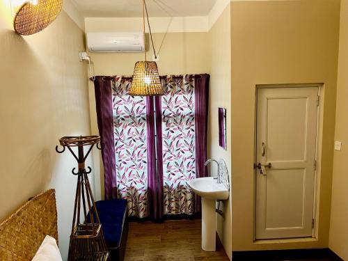 巴拉特布尔Paris Guest House的一间带水槽的浴室和一扇窗户的门