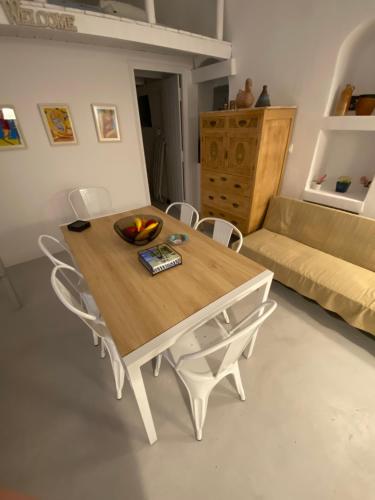 安坡里奥圣托里尼Villaggio One的带沙发的客厅配有桌椅