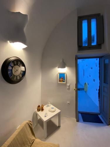 安坡里奥圣托里尼Villaggio One的一间带时钟、桌子和门的客厅