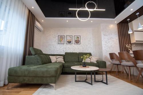 阿然德洛维克Hemingway LUX的客厅配有绿色沙发和桌子