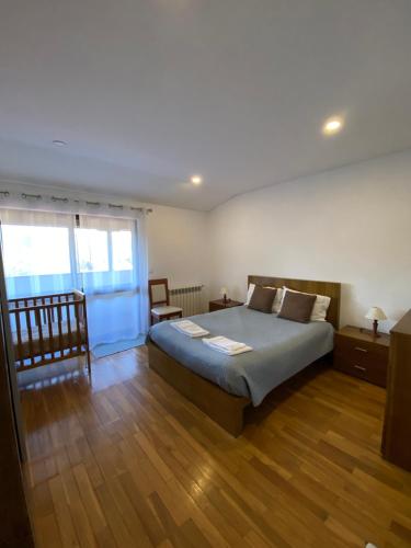 吉尔斯Casa de Casarelhos - Casa de férias - Gerês的一间卧室设有一张大床和一个窗户。