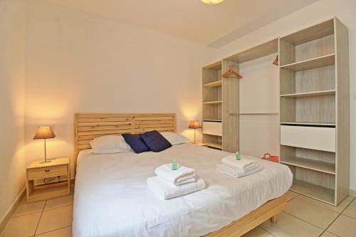 尼姆L'Ecluse - Clim - Parking - Central的一间卧室配有带毛巾的床