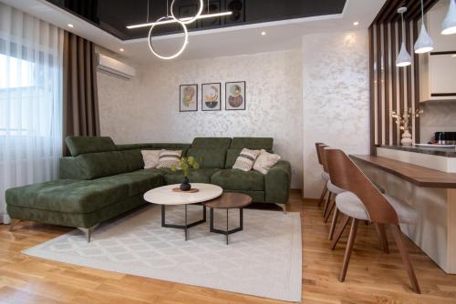 阿然德洛维克Hemingway LUX的客厅配有绿色沙发和桌子