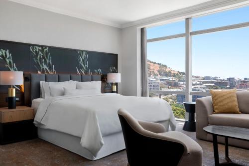 开普敦开普敦威斯丁酒店的卧室设有一张白色大床和大窗户
