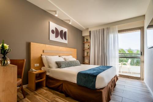 埃拉特Jacob Eilat的酒店客房设有一张床和一个大窗户