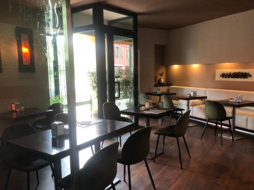 博尔戈马内罗HOTEL DEL CORSO的一间在房间内配有桌椅的餐厅