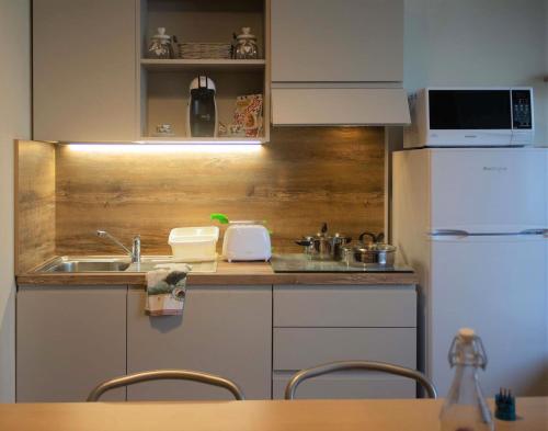 瓦尔博若纳Appartamento OUT OF TIME的一间带水槽和冰箱的小厨房