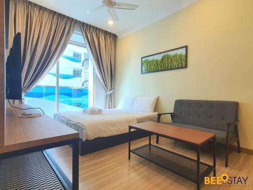 马六甲The Wave Suites Melaka by BEESTAY的一间卧室配有一张床、一张沙发和一个窗口