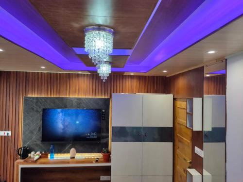 西姆拉Shimla Abode的一间配有电视和紫色天花板的客房