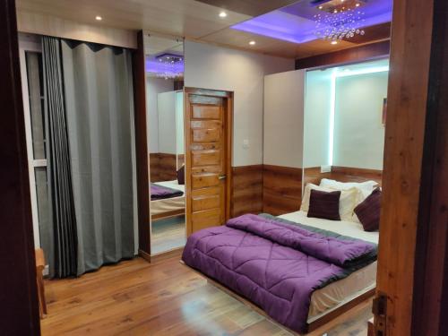 西姆拉Shimla Abode的一间卧室配有一张紫色的床和镜子