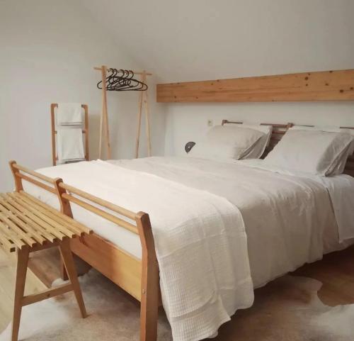MéryPaulette à bicyclette的卧室配有白色大床和木凳