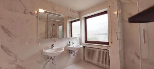 巴林根Stilvolles Haus 124 qm的浴室设有2个水槽、镜子和窗户。