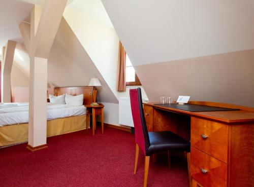 普劳西Hotel und Restaurant Haus Sajons的一间卧室配有一张床和一张桌子及椅子