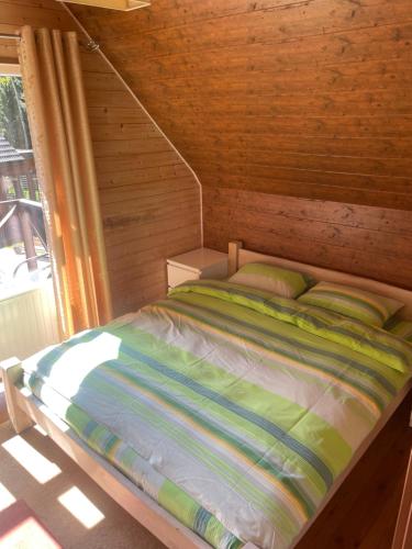 维尔纽斯Rustic private Cabin in woods w/ Sauna & Pool的木制客房的一张床位,设有窗户