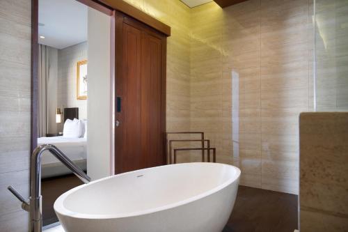 塞米亚克The Claremont Luxury Villas的带浴缸的浴室和卧室