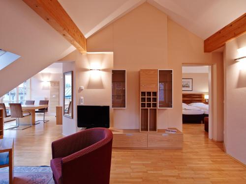 萨尔茨堡达斯格伦博斯特酒店赛科尼公寓式酒店的带电视的客厅和卧室。