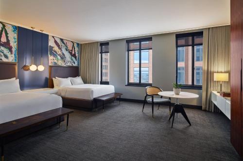 达拉斯Renaissance Saint Elm Dallas Downtown Hotel的酒店客房设有两张床和一张桌子。
