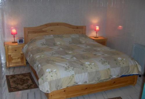 马拉喀什Villa Romancia Ourika Vallee的一间卧室配有一张大床,桌子上放着两盏灯