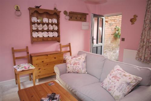 莱明斯特The Gardener's Cottage的客厅配有沙发和桌子
