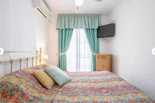 内尔哈El Eden的一间卧室设有一张带电视和窗户的床。