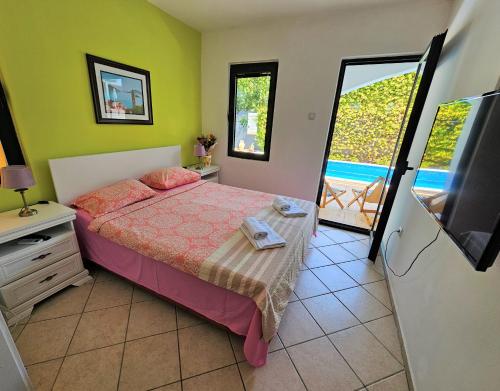 布德瓦Klaris Guest house的一间卧室设有一张带电视的床和一个阳台。