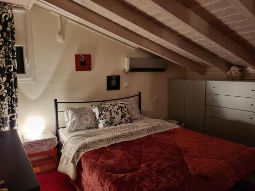 AgriovótanonEloise的一间卧室配有一张红色棉被的床