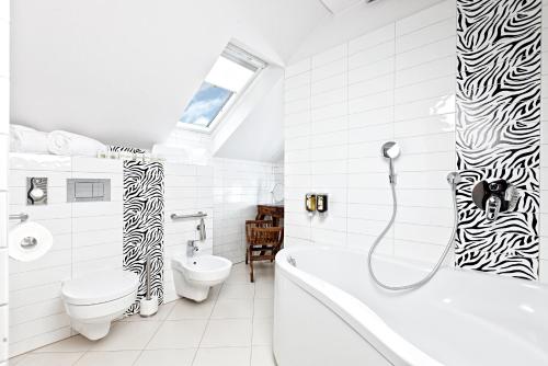 弗罗茨瓦夫Constantia by Grape Hotel的带浴缸、卫生间和盥洗盆的浴室