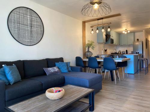 比斯卡罗斯Blue ocean的一间带蓝色沙发的客厅和一间厨房