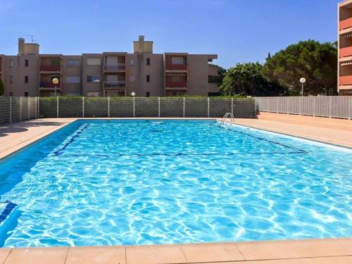博尔马斯·莱斯·米默萨斯studio cabine quatre couchages classé 2 étoiles的一个大型蓝色游泳池,其建筑背景为: