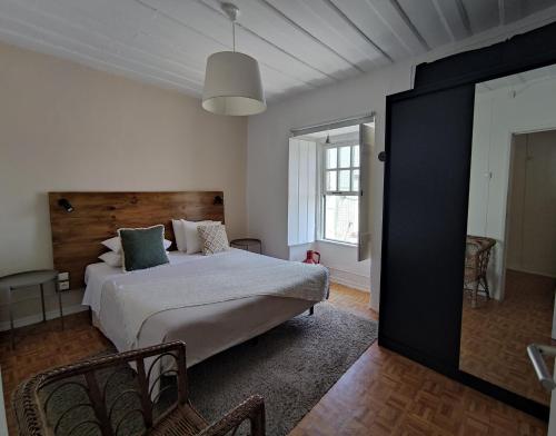 托里什韦德拉什Historic Torres Vedras的一间卧室设有一张大床和一个大镜子