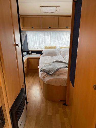 韦斯特曼纳埃亚尔Cozy Caravan的一个小房间的小床,设有窗户
