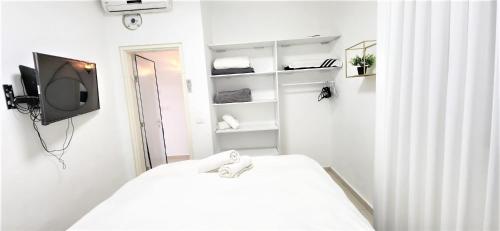 埃拉特sea view & pool eilat的白色的客房配有床和电视。