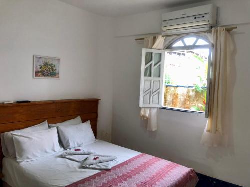 伊塔帕里卡Pousada Ponta de Areia的一间卧室设有一张床和一个窗口