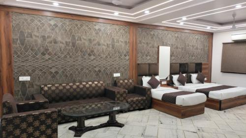 新德里HOTEL SINGH CONTINETAL的客房设有两张床、一张沙发和一张桌子。