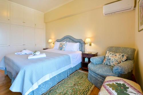AnemómylosCorfu Ionian Blue的配有一张床和一把椅子的酒店客房
