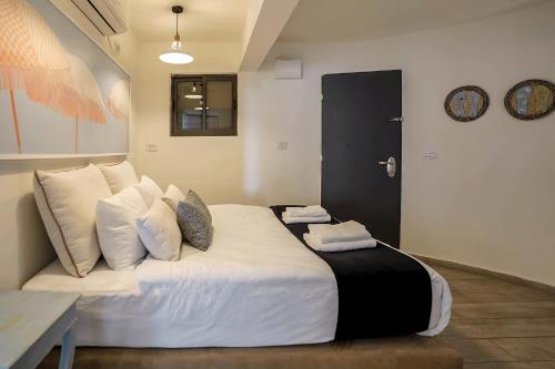埃拉特YalaRent Cliff side villa with private pool的卧室配有一张带白色床单和枕头的大床。