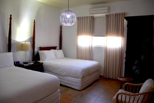 拉哈斯Turtle Bay Inn的酒店客房设有两张床和吊灯。