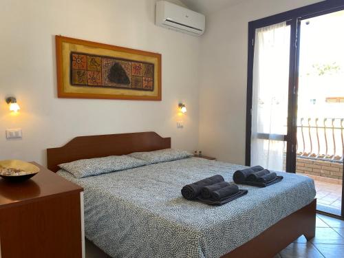 皮诺港Casita Porto Pino的一间卧室配有一张床,上面有两条毛巾