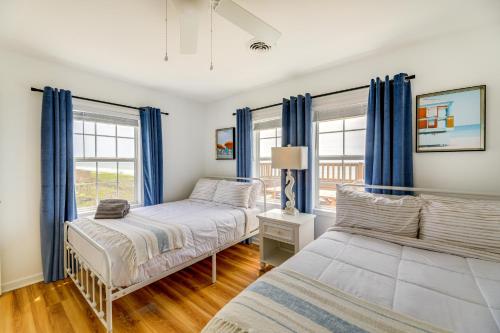 翡翠岛Beachfront Emerald Isle Vacation Rental with Deck!的一间卧室设有两张床和蓝色窗帘