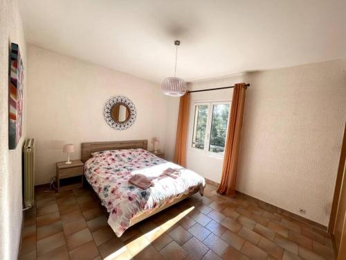 布克贝莱尔Villa Terres Blanches à 10 min d'Aix-en-Provence的一间卧室配有一张床、镜子和窗户